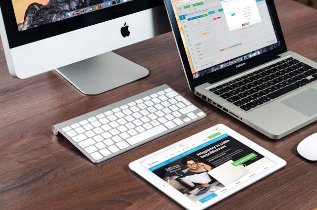 A computer, tablet, and phone on a desk with IDEs for Python on macOS displayed on their screens