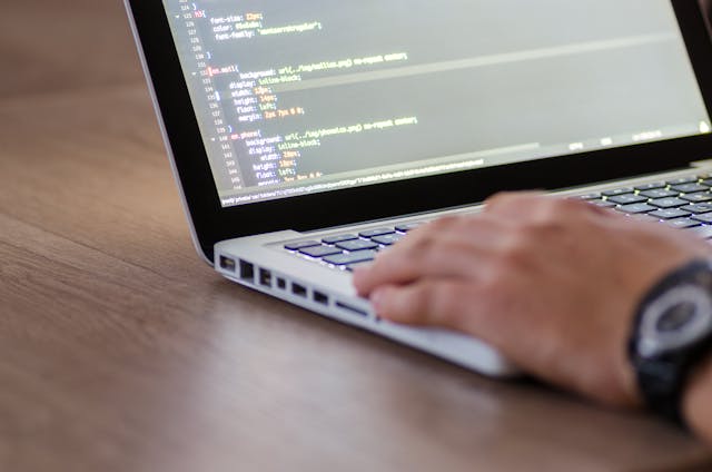 A person typing on a laptop with programming code on the screen. JSONL Format.